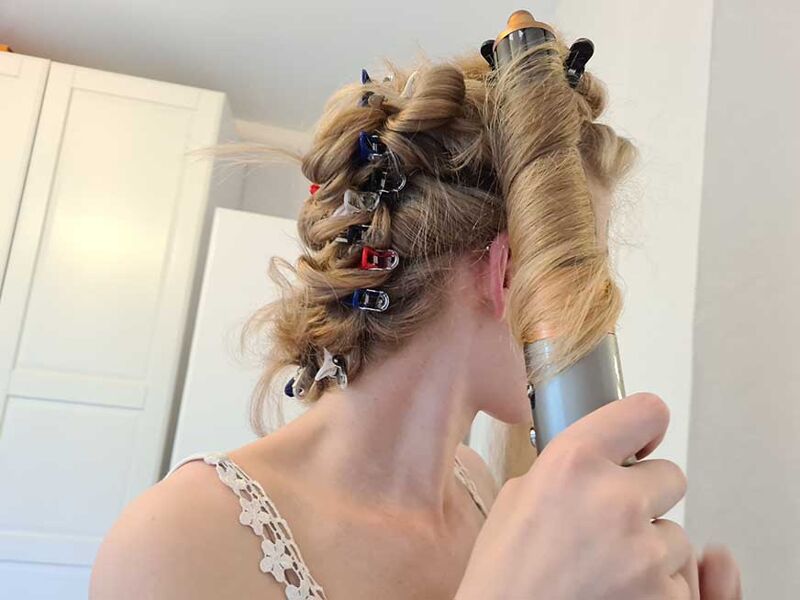 Woman styling her hair with the Dyson Airwrap.